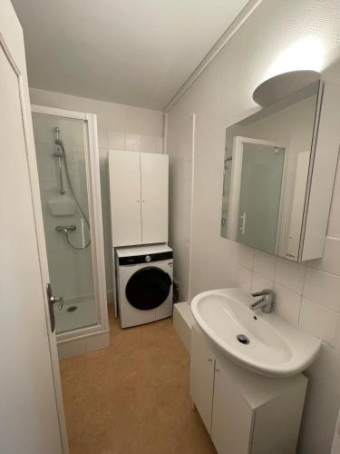 a white bathroom with a sink and a shower at Apartment with exceptional views in Saint-Nazaire