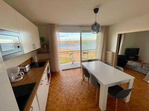 een keuken met een witte tafel en uitzicht op de oceaan bij Apartment with exceptional views in La Celle-sous-Gouzon