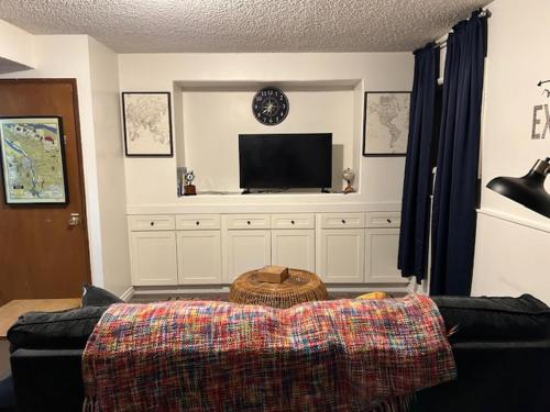 a living room with a couch and a flat screen tv at Cozy East County Jewel in Portland