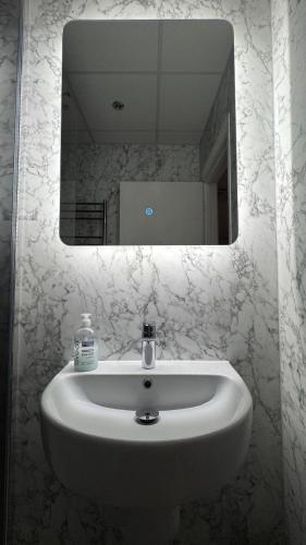 a white sink in a bathroom with a mirror at The March Hotel in March