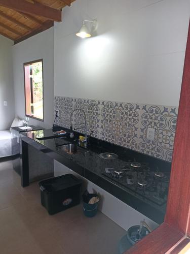 a kitchen with a sink and a counter top at Chalé caminho das cachoeiras in São Thomé das Letras