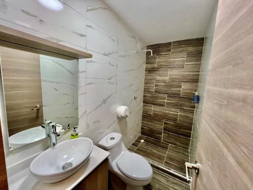 a bathroom with a sink and a toilet and a mirror at Hotel Bello Horizonte in Santa Marta