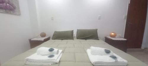 een witte slaapkamer met een bed met handdoeken erop bij GR Hotel in La Rioja