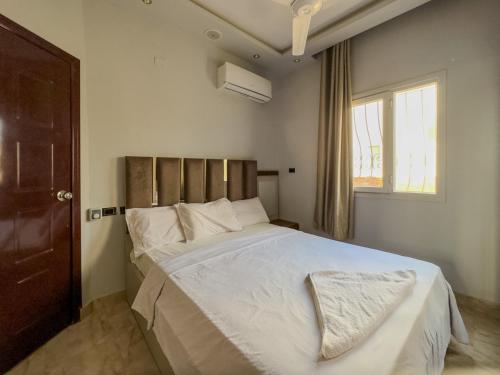 a bedroom with a bed with white sheets and a window at 129 · 2BR Townhouse 2 Bath TV Backyard in Sheikh Zayed