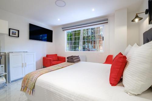 a bedroom with a large white bed and red chairs at Casa Ama in Mexico City