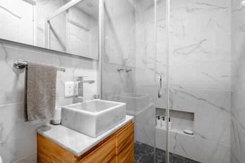 a white bathroom with a sink and a shower at Casa Ama in Mexico City