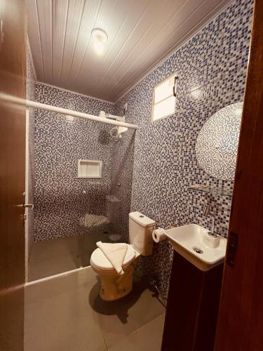 een badkamer met een toilet, een wastafel en een douche bij Shalon Adonai by Martinelli in Fernando de Noronha