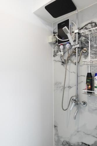 a shower in a room with white marble at Nadi Easy Stay Near McDonalds in Nadi