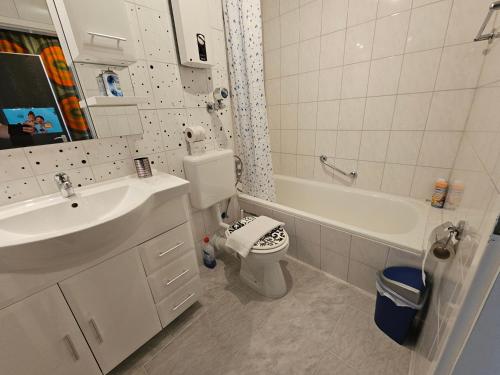 a bathroom with a sink and a toilet and a tub at King Apartment Luftkurort Bayerischen Wald in Sankt Englmar