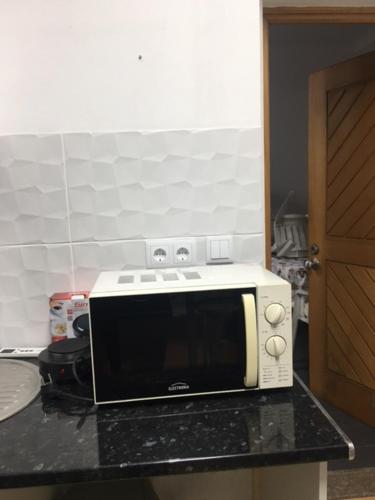 een magnetron op een aanrecht in een keuken bij Casa cidade e piscina in Coimbra