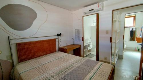 een slaapkamer met een bed in een kamer met een spiegel bij Casa Dendê Praia do Forte in Praia do Forte