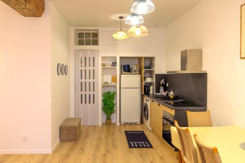 a kitchen with a table and a white refrigerator at Kait location in Pont-sur-Yonne