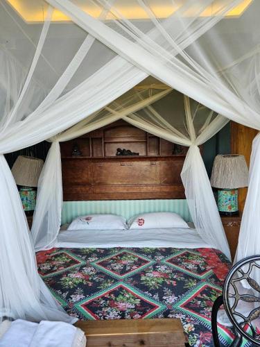 a bedroom with a bed with a canopy at The Chaisai Private Lodge in Ban Huai San Mai