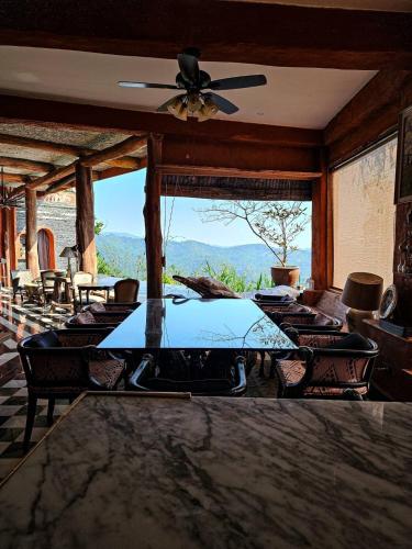 a dining room with a table and chairs and a ceiling fan at The Chaisai Private Lodge in Ban Huai San Mai