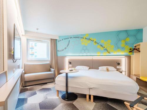een slaapkamer met een bed en een muur met een muurschildering van bloemen bij ibis Styles Strasbourg Stade de la Meinau in Straatsburg