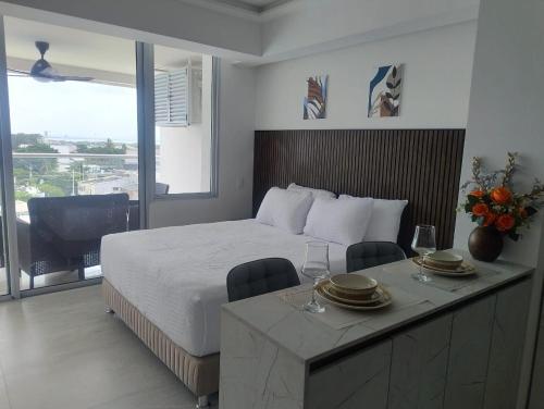 a bedroom with a bed and a table with plates and wine glasses at Magica Cartagena Suite in Cartagena de Indias
