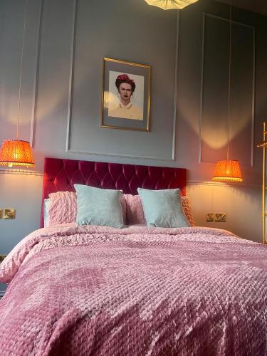 a bedroom with a purple bed with two lamps at The Bank - Rooms & Apartments by Coorie Doon Stays in Troon