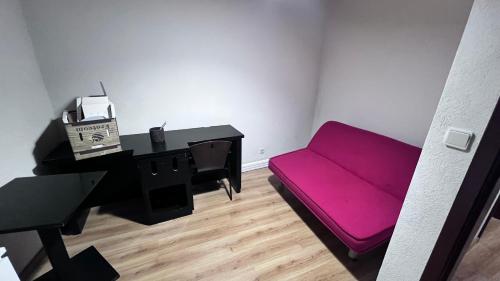 een woonkamer met een paarse bank en een piano bij Leomil-House in Leomil