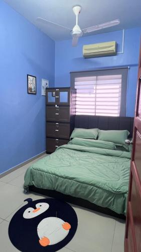 a bedroom with a bed and a blue wall at Rumah Inap CT DGadek - Islamic Rest House CT DGadek 住宿加早餐 - 伊斯兰休息屋 in Alor Gajah