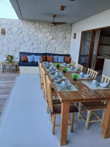 een lange houten tafel en stoelen in een kamer bij Casa Alvorada - Villa Vento in Camocim