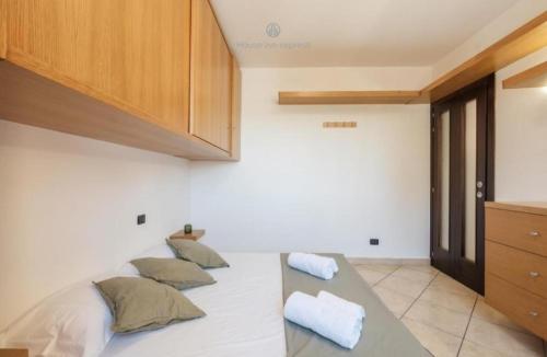 a room with a bed with four pillows on it at Dimora Karalis in Cagliari