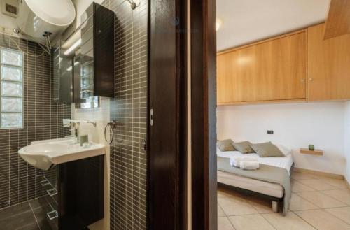 a bathroom with a sink and a bed in a room at Dimora Karalis in Cagliari