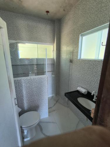 a bathroom with a toilet and a sink and a window at Varanda do Céu Paraty in Paraty