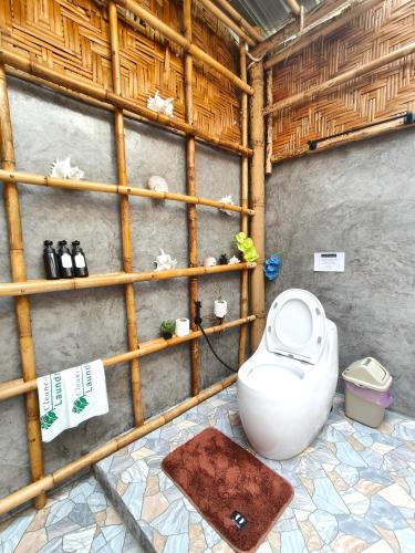 a bathroom with a toilet in a bamboo wall at Laeley 1,000 miles resort in Ko Lanta Yai