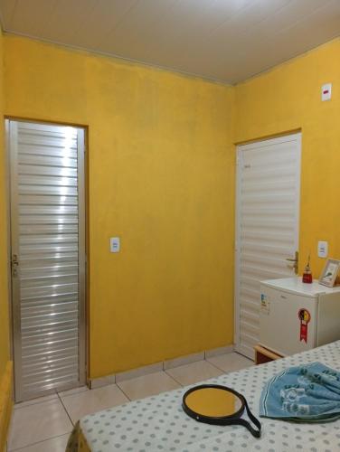 a bedroom with two beds and a yellow wall at HOSPEDARIA RECANTO Do MATIAS in Barreirinhas