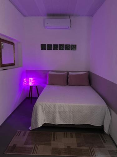 a bedroom with a bed with purple lights on it at Espaço para Hermanos in São Gabriel