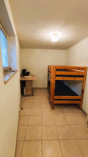 a room with a bunk bed and a desk at Souterrainwohnung in Niederau in Niederau