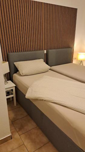 a bedroom with two beds and a wooden headboard at Zimmervermietung Heggemann in Lingen