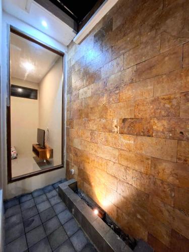 a brick wall in a room with a window at Omi Homestay in Praya