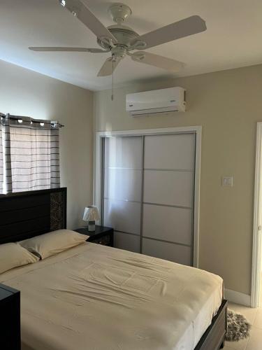 a bedroom with a bed and a ceiling fan at Gate home by ocean point in Lucea