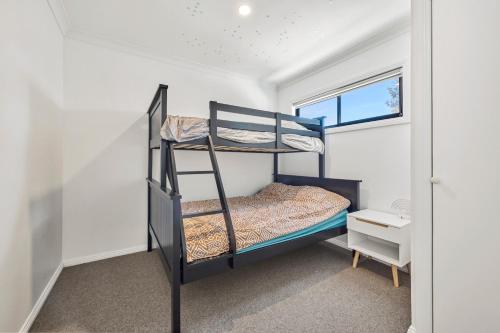 a bedroom with two bunk beds and a window at Wheeler's Paradise in Paradise Beach