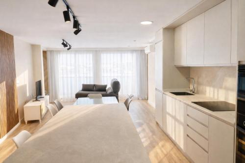 een keuken en woonkamer met een tafel en een bank bij El Ático in Gandía