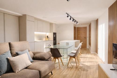 een woonkamer met een bank en een glazen tafel bij El Ático in Gandía