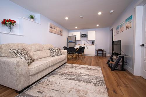 a living room with a couch and a kitchen at Richie's Place A Cozy 2-BR Apt in Fredericton in Fredericton