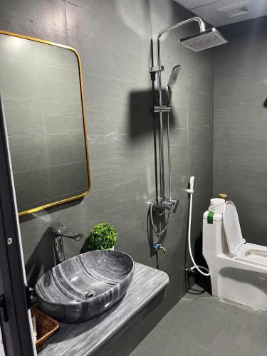 a bathroom with a sink and a toilet and a mirror at Shang Hotel in Uoc Le (1)