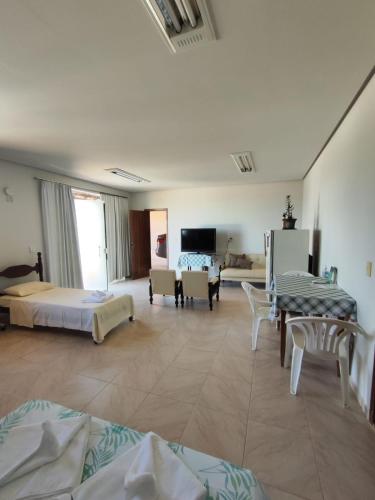 a hotel room with two beds and a living room at Suíte na Canastra com Ar Condicionado in São Roque de Minas