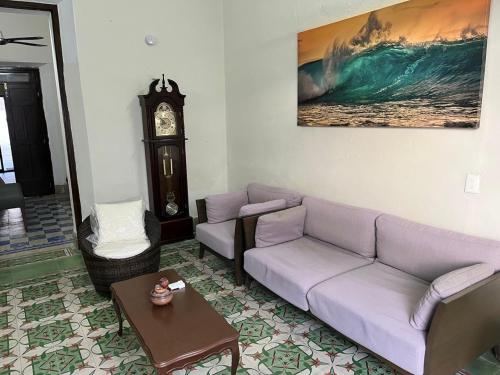 a living room with a purple couch and a clock at Casa Sierra in Mérida