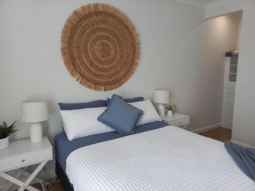 a bedroom with a bed with blue and white sheets at Lillian Waters Retreat in Yamba