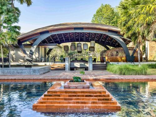 a swimming pool with a fountain in front of a building at Veranda High Resort Chiang Mai - MGallery Collection, Accor Hotel in Hang Dong