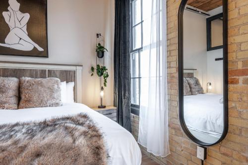 a bedroom with a bed and a mirror at Bradshaw Lofts The Brixton King Suite in Stratford