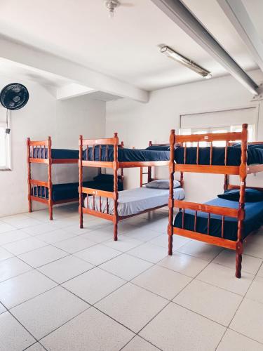 a room with three bunk beds in a room at Surf & Arte Hostel in Cabo Frio