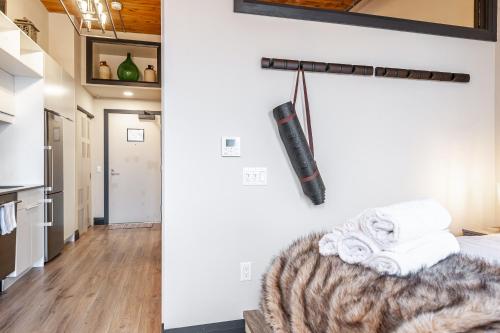 a room with a bed and towels on a wall at Bradshaw Lofts The Brixton King Suite in Stratford