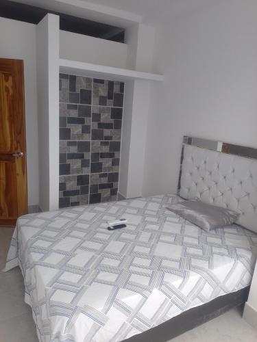 una camera da letto con un letto con un controller sopra di Acogedor apartamento a Apartadó