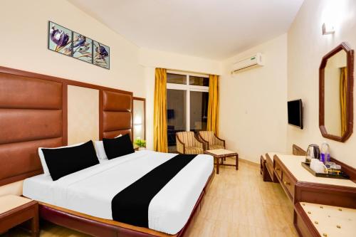a hotel room with a bed and a desk at Townhouse Oak Silver City Chowk Formerly HW Residency in Dehradun
