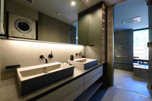 a bathroom with two sinks and a large mirror at Villa Cielo Hakone Luxury - Mt Fuji View Private Onsen & Sauna シエロ箱根仙石原 in Hakone