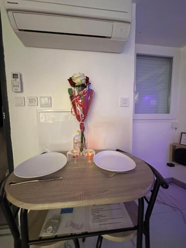 een tafel met twee borden en een vaas met bloemen erop bij Asdreamslove in Alès